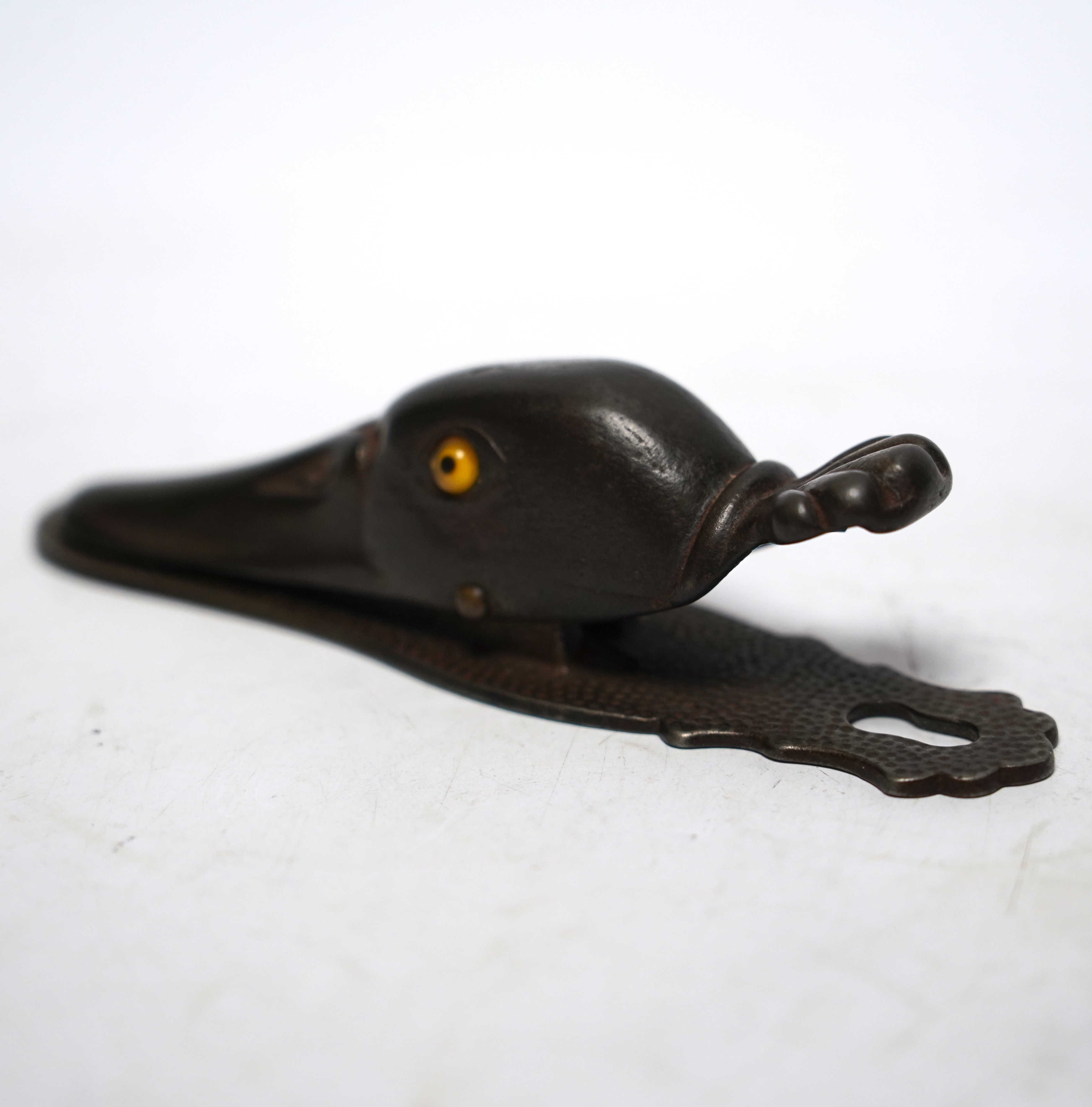 A base metal, glass eyed duck’s head letter clip, with stamp on base: 5180, 13cm long